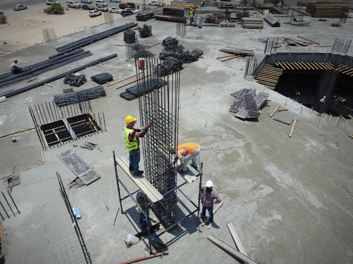 A general contractor estimator reviewing bid clarifications and scope notes at a construction office desk.
