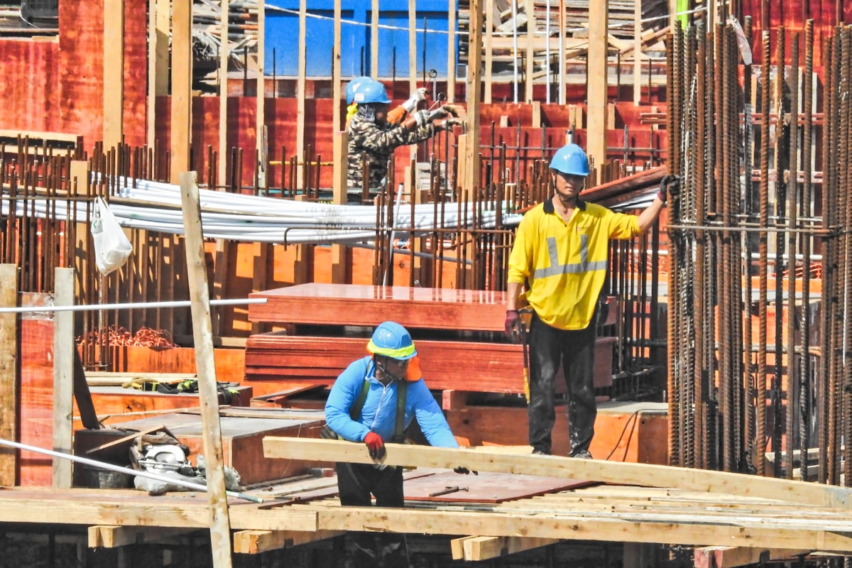 A general contractor estimator reviewing subcontractor bids and trade coverage on a desktop workstation.