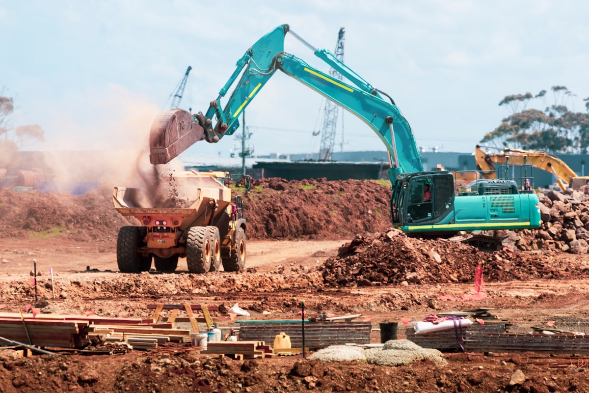 A general contractor project manager reviewing subcontractor documentation at a preconstruction office desk.
