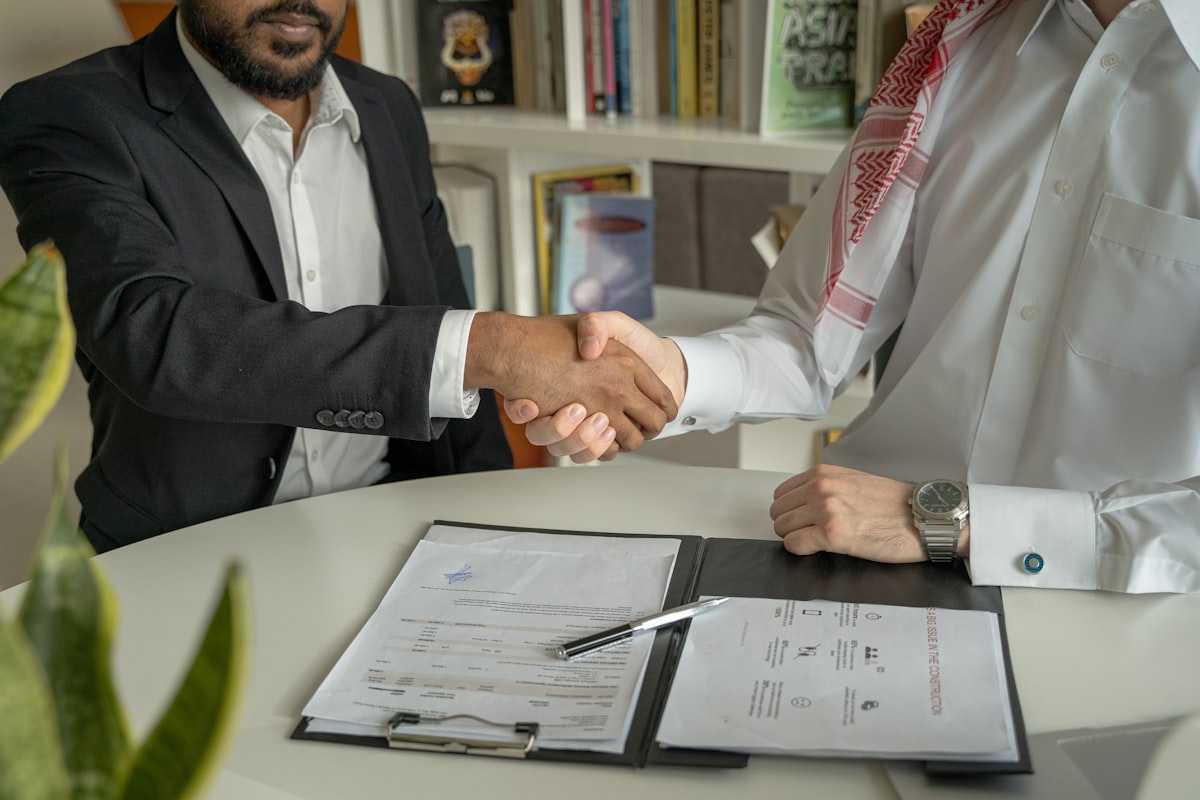 Two construction executives reviewing financial documents during an ownership transition planning meeting.