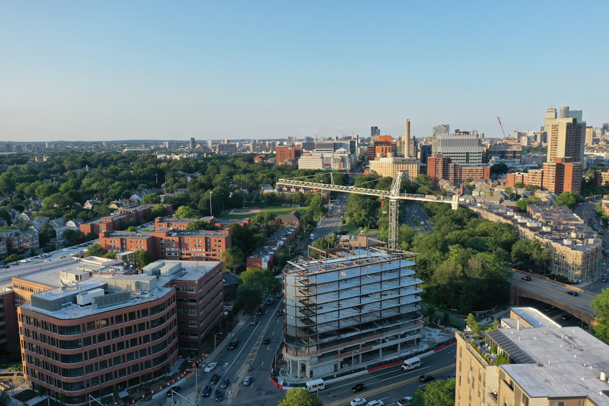 Aerial view of a nonresidential construction site showing crane activity across multiple building segments.