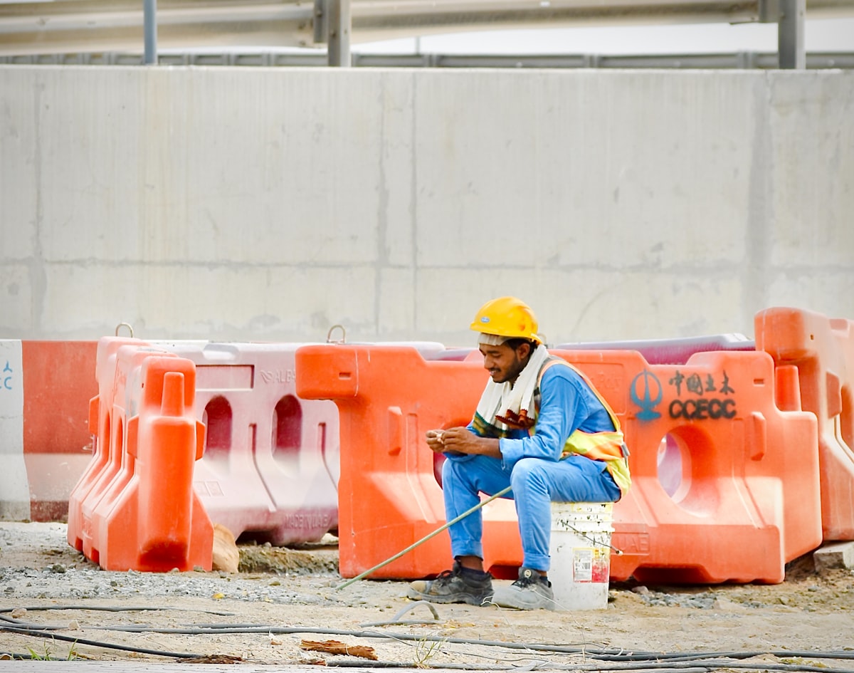 An estimator reviewing project data on a tablet at an active construction site, representing the shift toward connected jobsite technology.