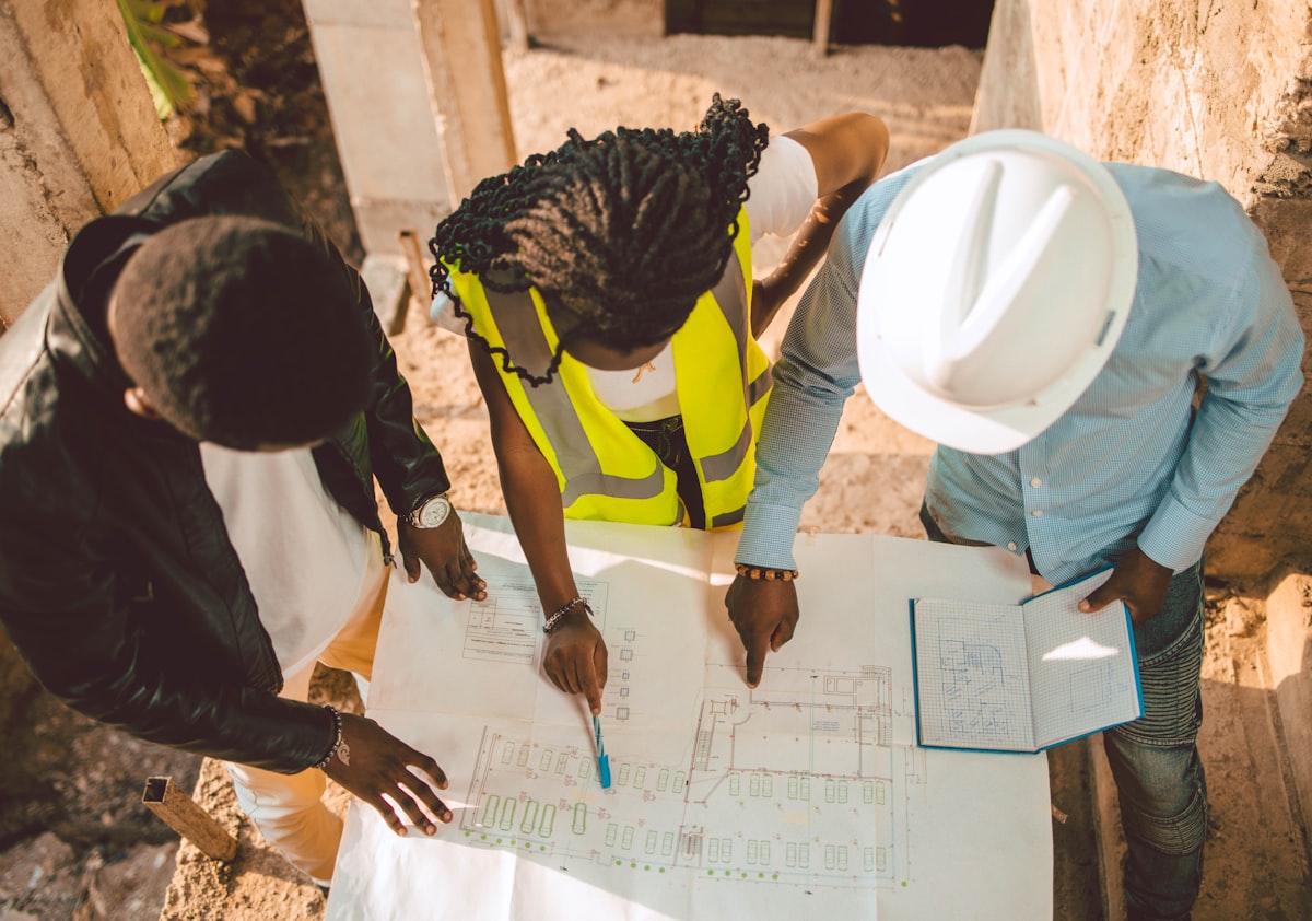 A construction project manager reviewing plans on site, reflecting the industry's growing white-collar workforce share.