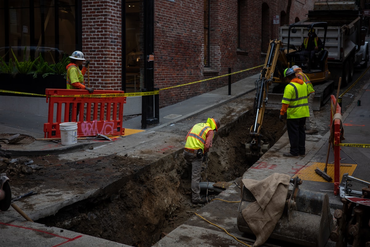 An excavation trench on an active construction site, illustrating jobsite safety liability questions GC estimators and project managers face when managing subcontractors.