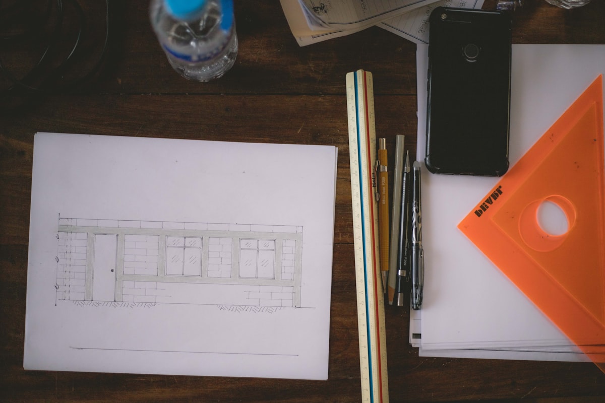 A senior GC estimator reviewing subcontractor bids and trade coverage on a preconstruction desk.