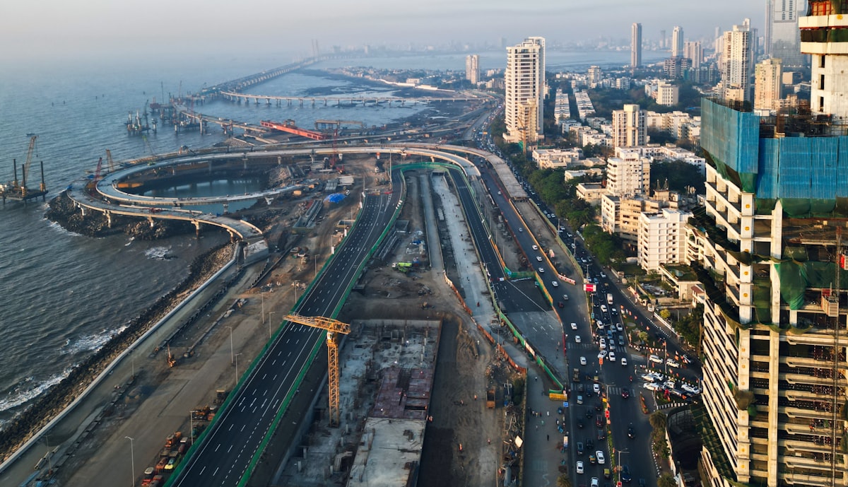Aerial view of a major highway construction project with active grading and paving operations underway.