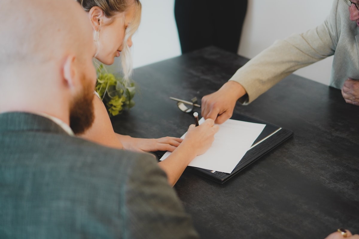 Construction contract documents on a desk, representing risk allocation and limitation of liability clauses in GC agreements.