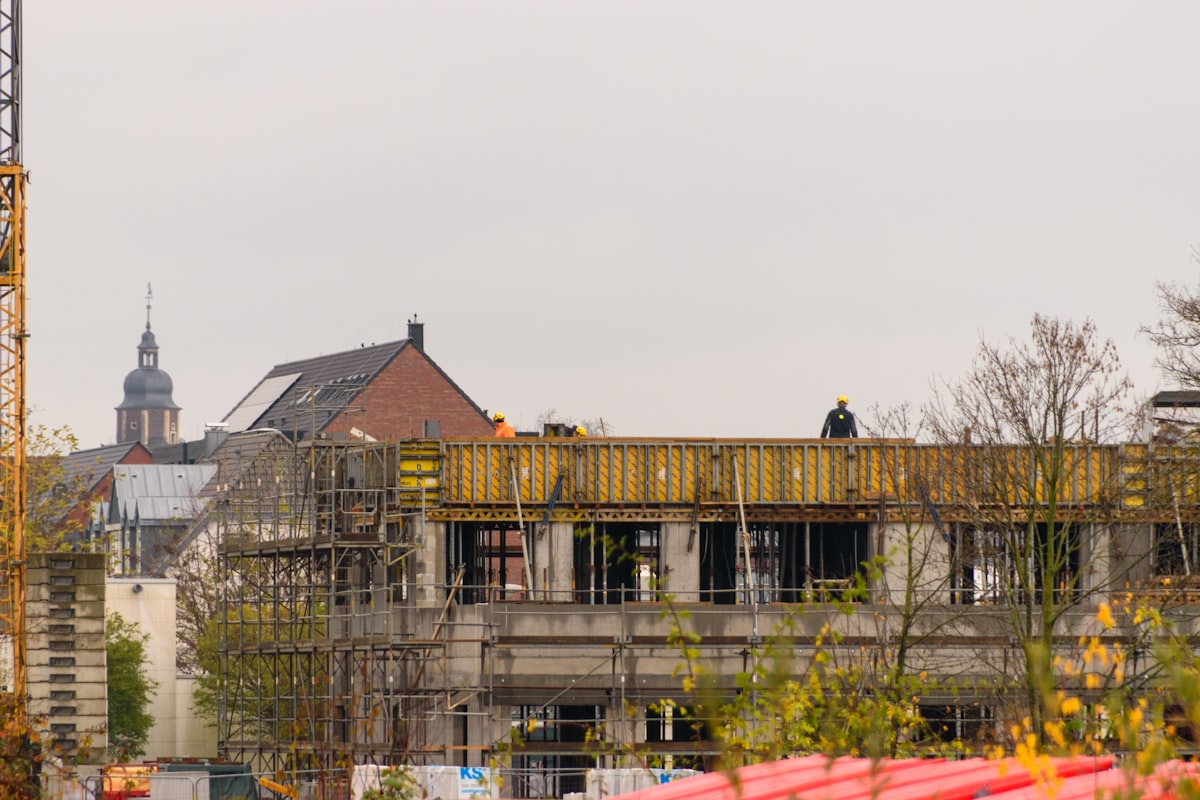 Construction crew working on a structural steel frame, reflecting regional labor market growth data.