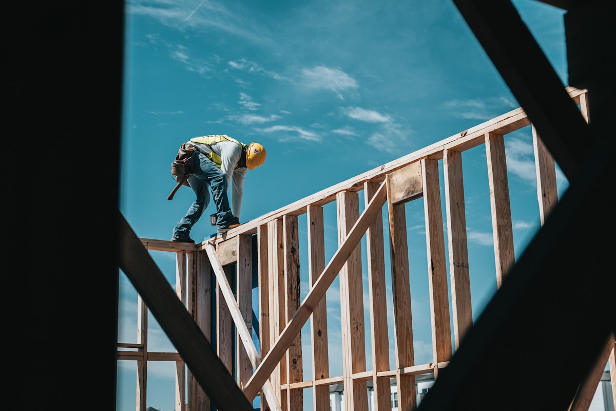 Wood framing of a new residential housing development under construction, viewed from ground level.