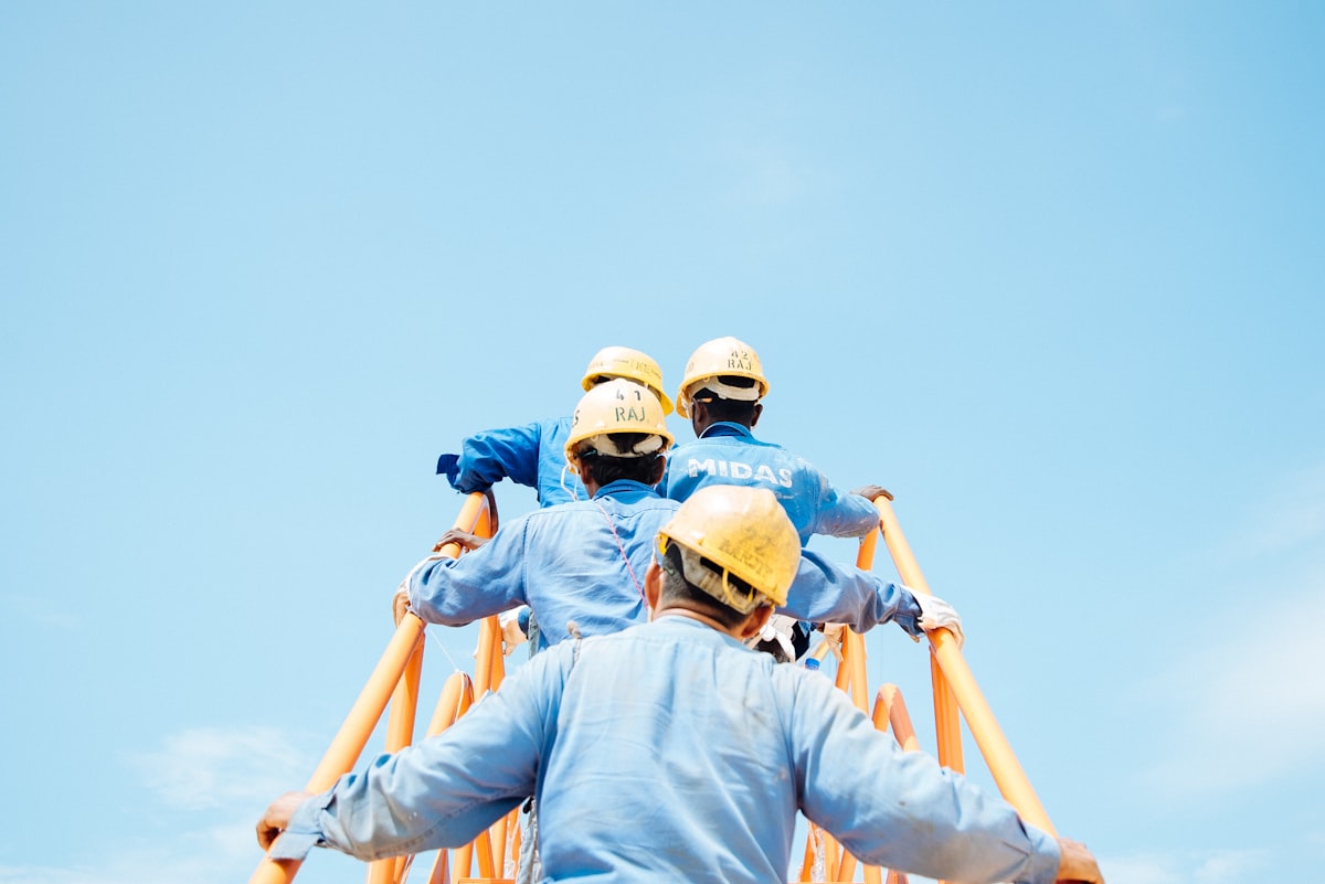 Construction workers in hard hats at a job site, representing workforce safety and development leadership in the industry.