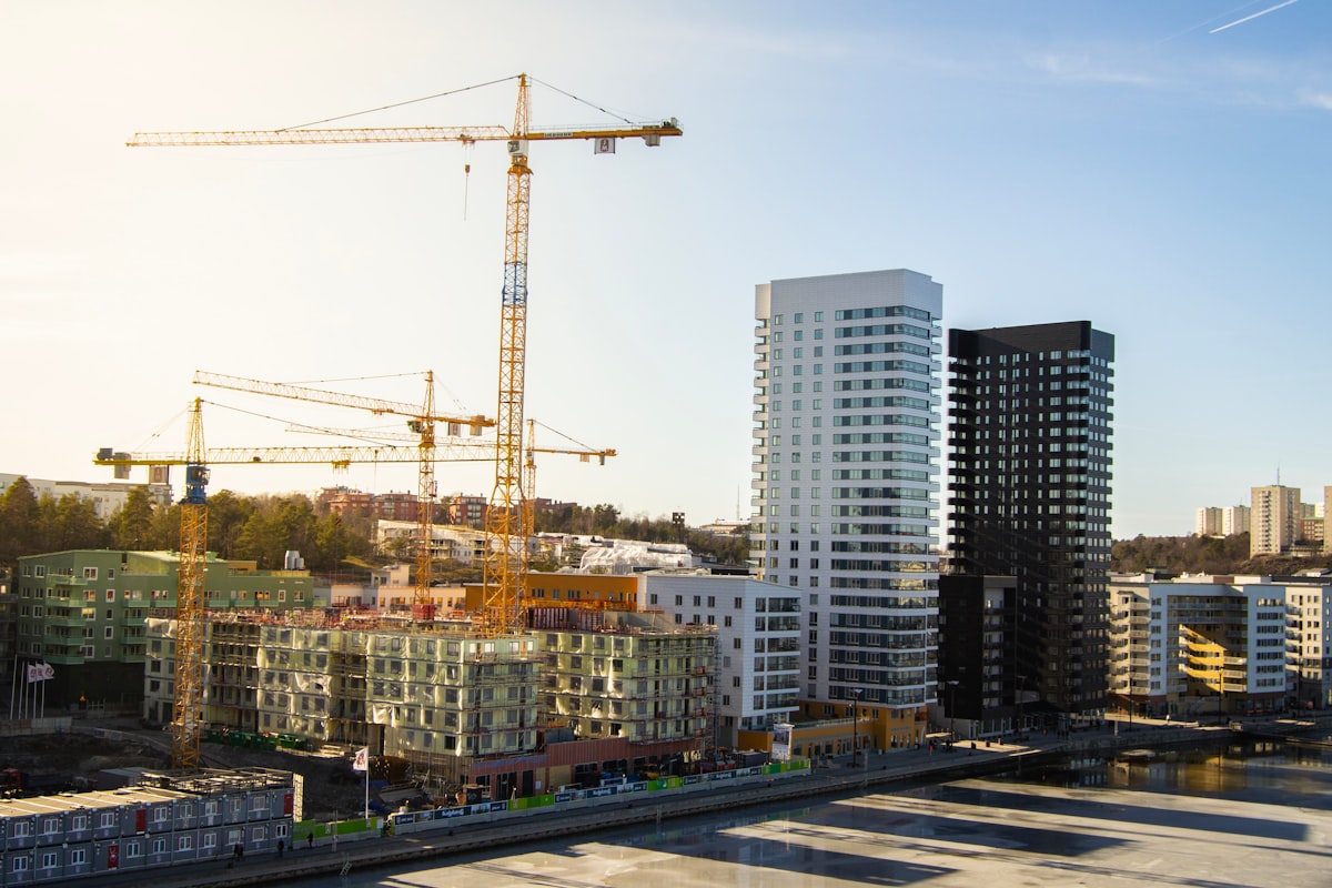 Aerial view of an urban construction site with cranes, representing mid-2026 market uncertainty for GC estimators.