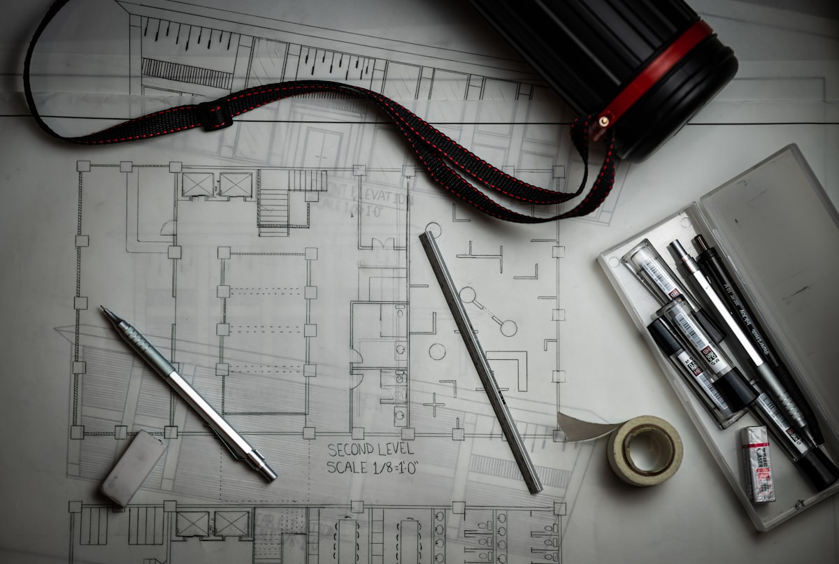A GC estimator reviewing a subcontractor scope sheet alongside construction drawings before sending out bid invitations.