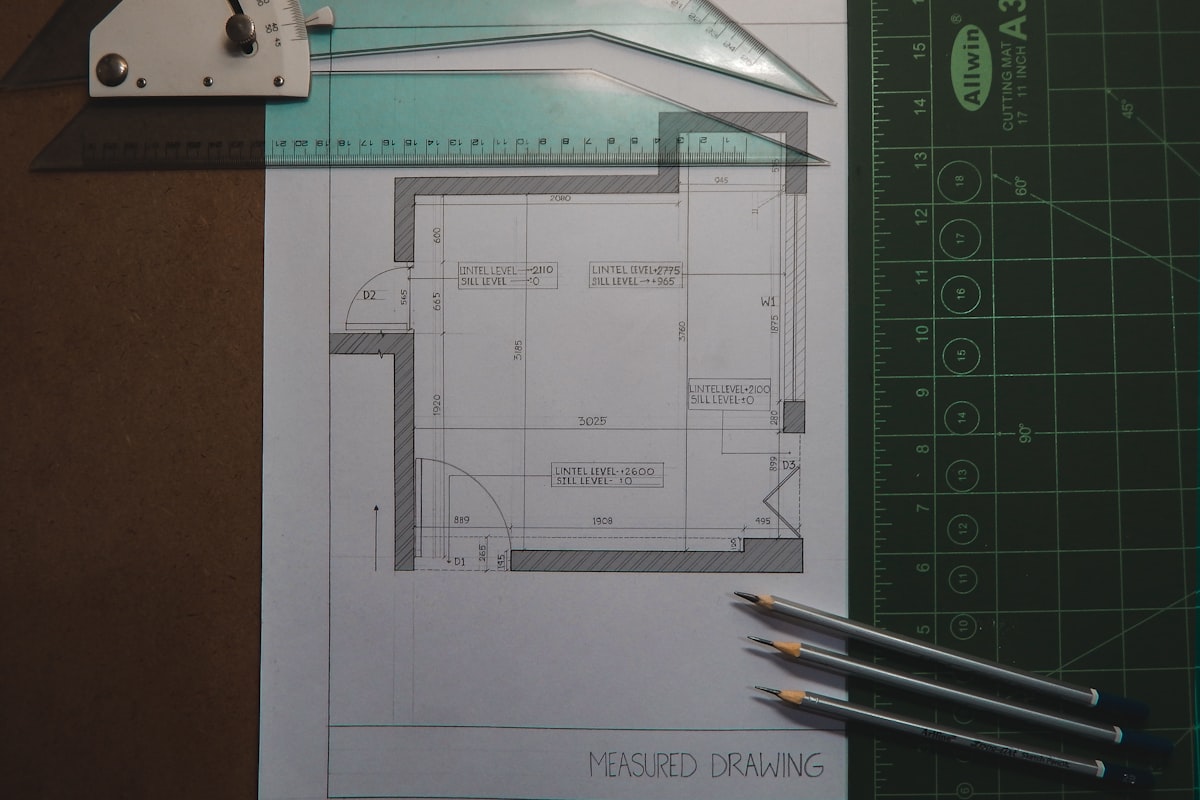 Estimator reviewing preconstruction documents and blueprints at a project planning desk.
